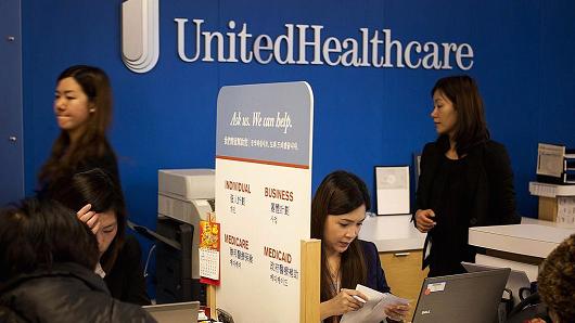 Representatives speak with customers at a UnitedHealthcare store in the Queens borough of New York, U.S., on Monday, Jan. 14, 2013.